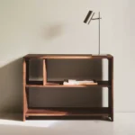 Karaağaçtan yapılmış, iki ayrı yükseklikte asimetrik raflı alçak kitaplık. Montaj gerektirir.